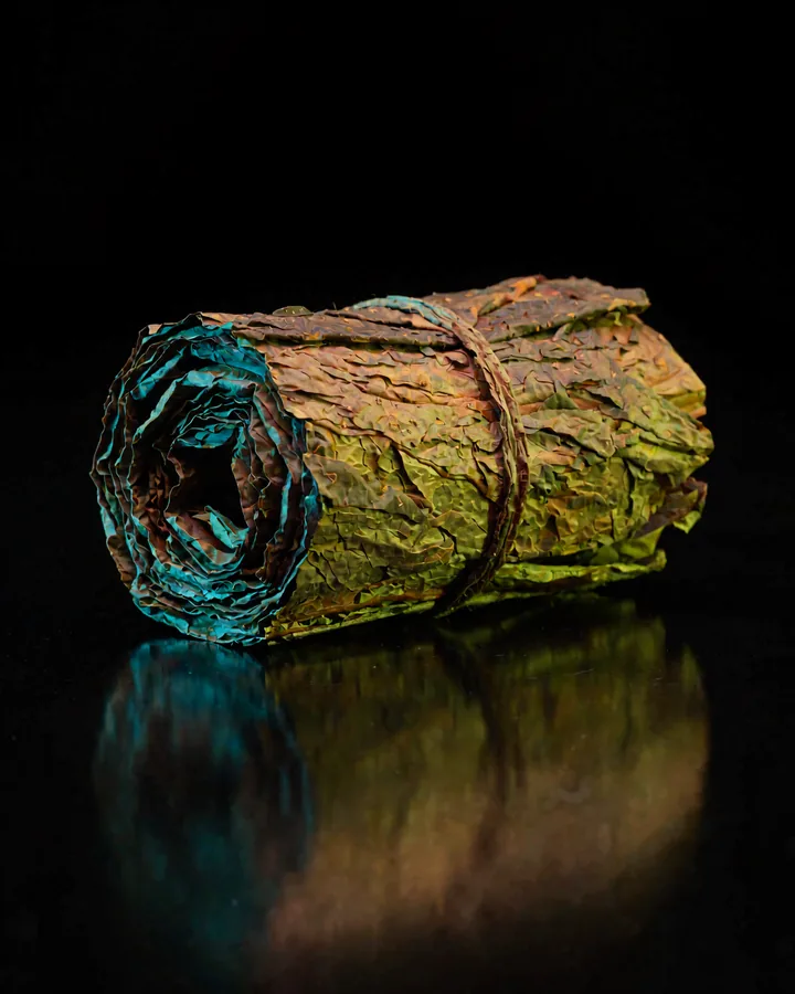 RY4 Tobacco — a rolled bundle of cured tobacco on black glass